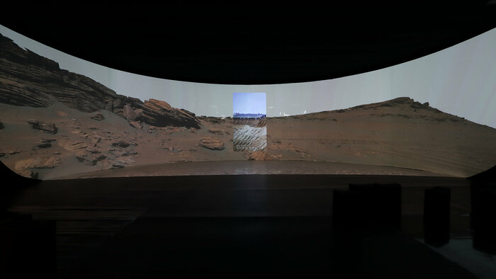 Foto des Videobeitrags "Passage" der Künstlerin Adina Camhy, zu sehen ist die Marsoberfläche und ein integriertes Foto von der Besetzung des Dorfes Lüzerath
